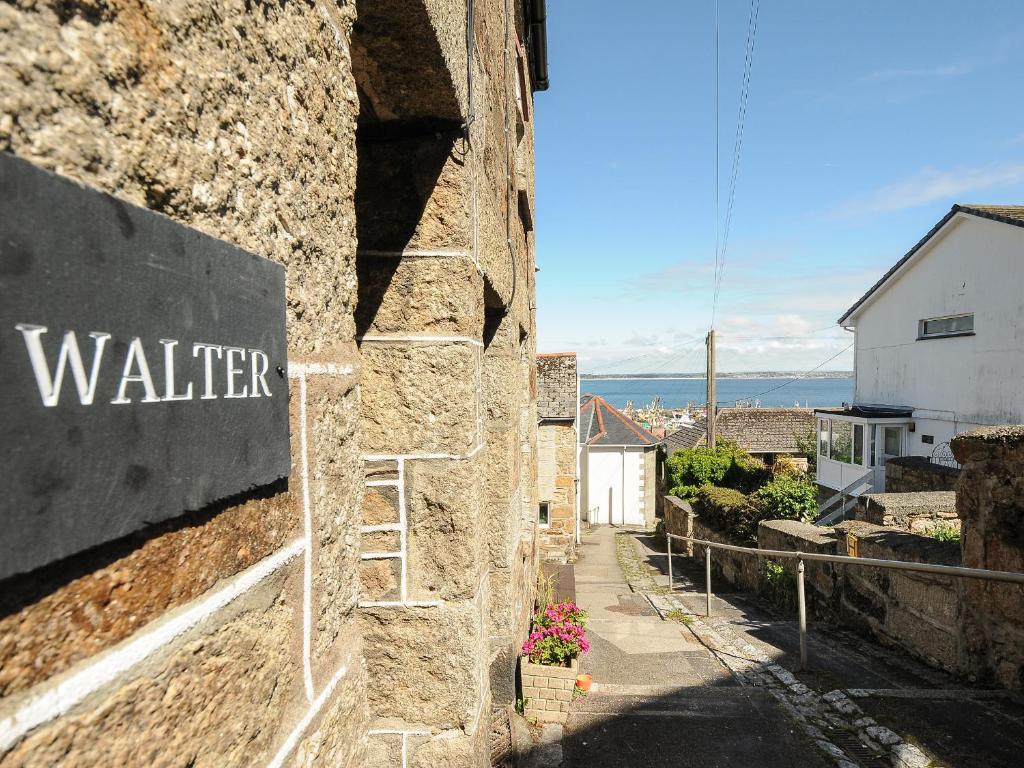 a sign on the side of a stone building at Walter in Penzance