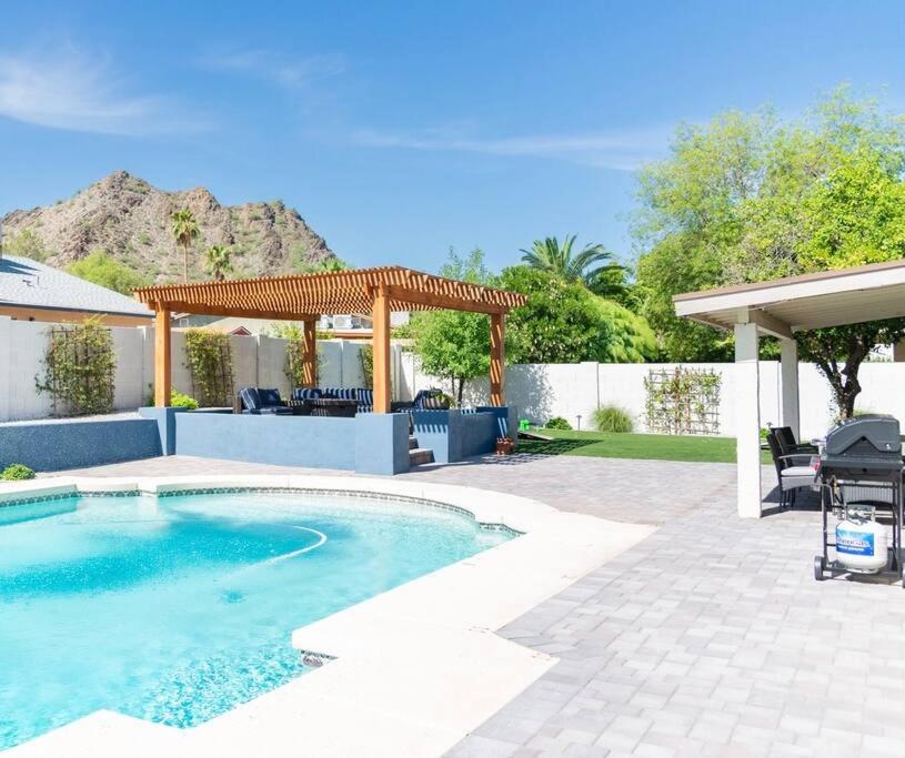 a swimming pool in a backyard with a pergola at Sunnyside of Life Retreat: Serene 5 BR with pool in Phoenix