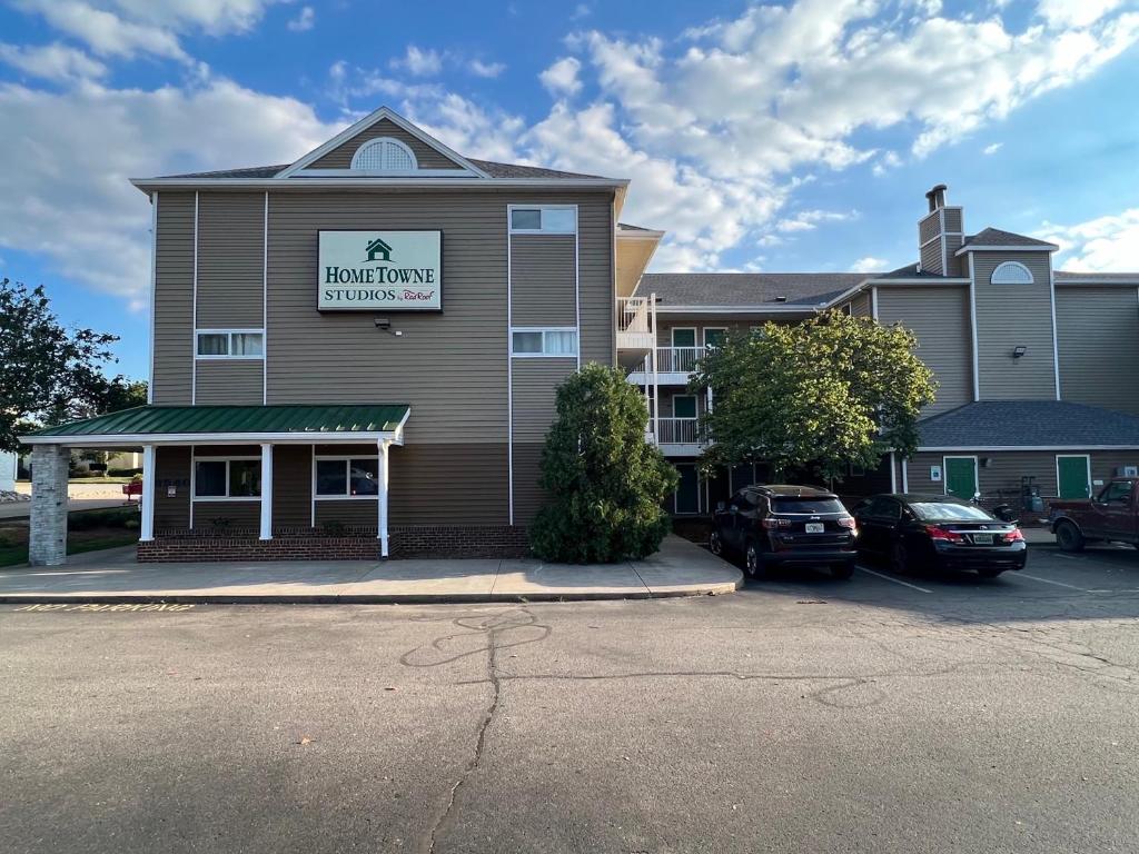 een vooraanzicht van een hotel met auto's geparkeerd op een parkeerplaats bij HomeTowne Studios by Red Roof Louisville in Louisville