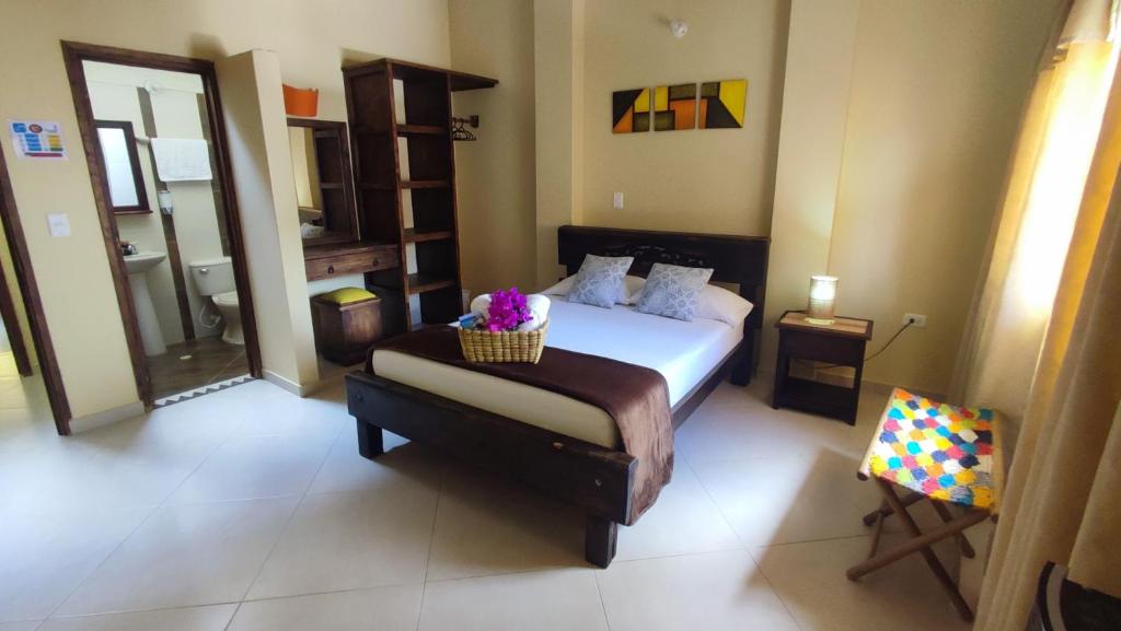 a bedroom with a bed with a basket of flowers on it at Macondo Hostel in San Gil