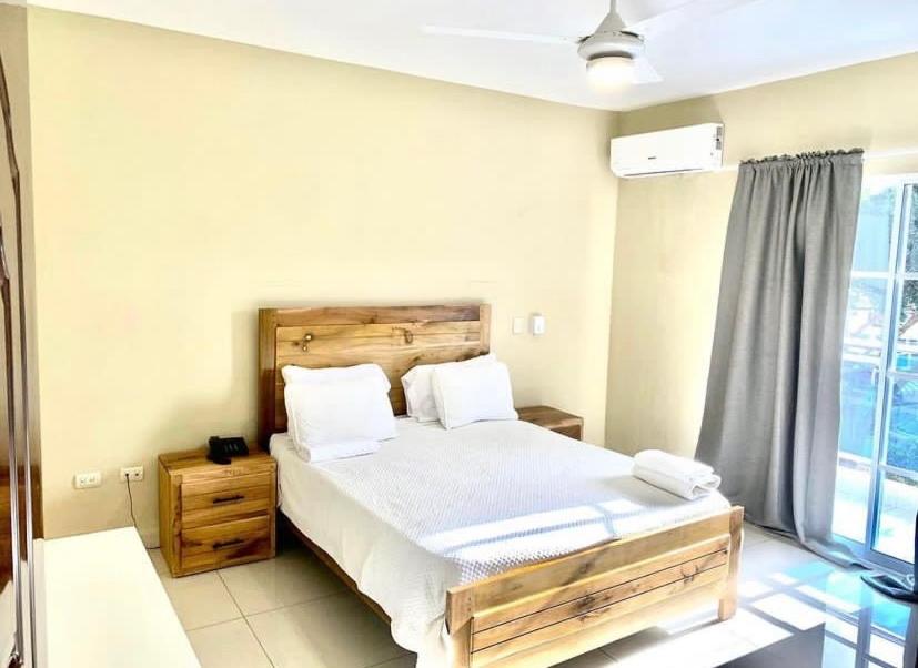 a bedroom with a large bed and a window at Lomas Hotel in San José de Ocoa