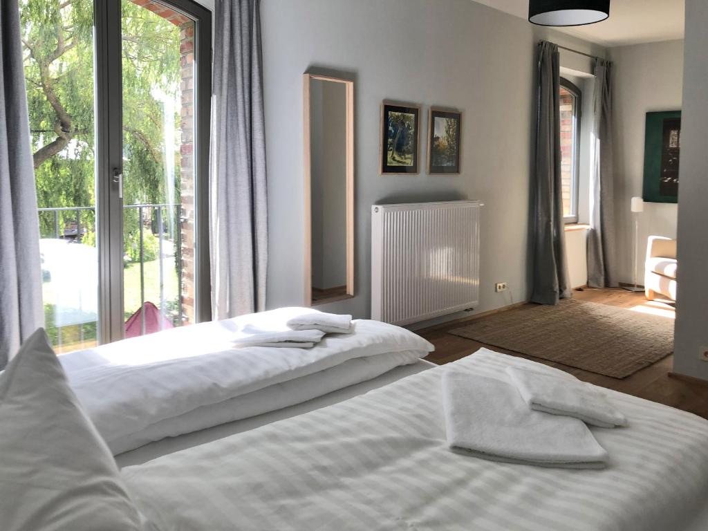 a bedroom with two beds and a large window at Hotel garni Hof Wetzenow in Rossow