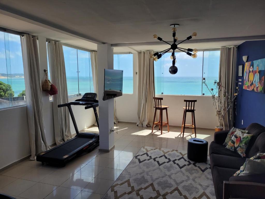 a living room with a television and a treadmill at Apartamentos Natal Ponta Negra Vista Espetacular para o Mar in Natal