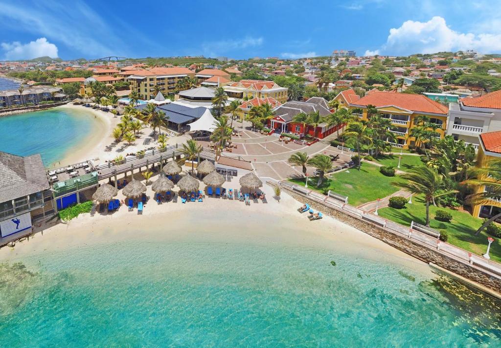 an aerial view of a beach with umbrellas and the ocean at Curacao Avila Beach Hotel in Willemstad
