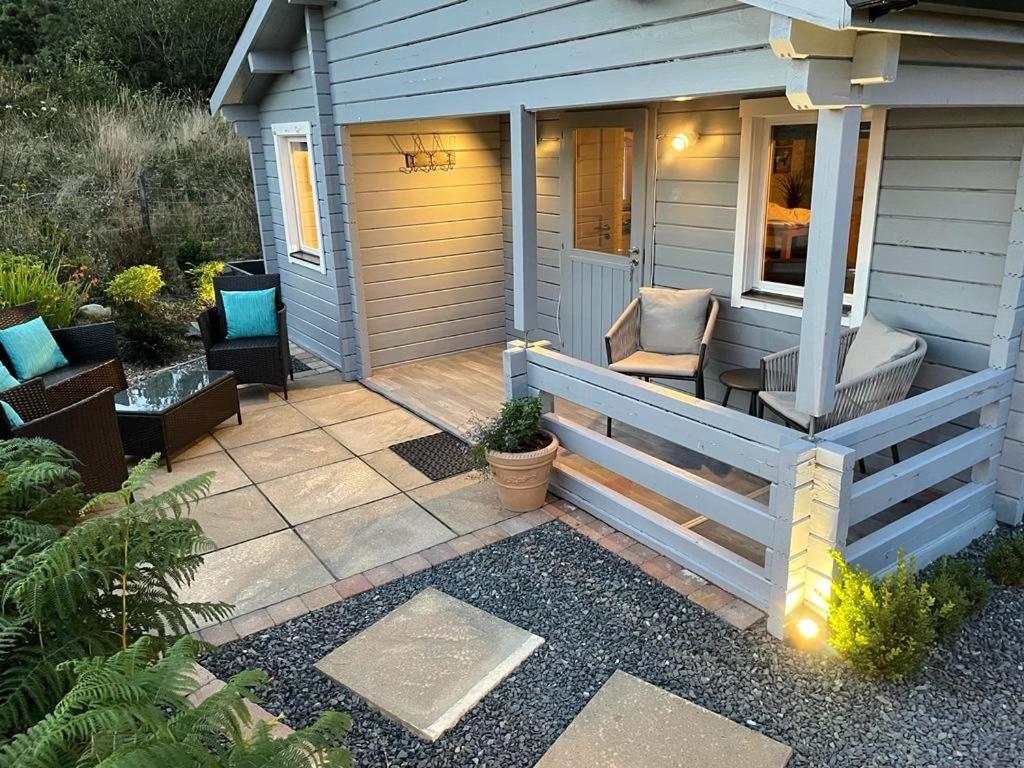 a porch of a house with a bench and a chair at Rockschapel Cabin 30B in Annacloy