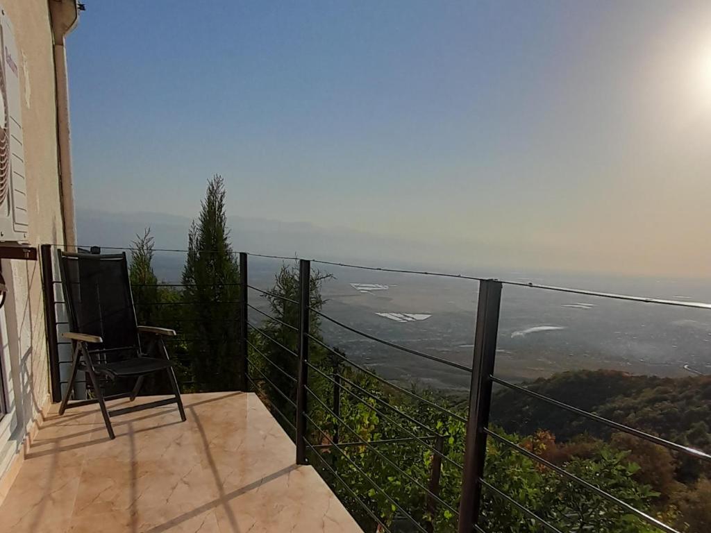 Un balcón con una silla y vistas al océano. en Abramichi Guest House, en Signagi