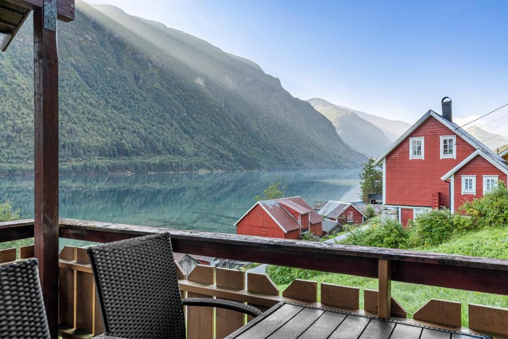 a view of a lake from a deck with chairs at Cabin alongside the beautiful fjærlandsfjord in Fjarland