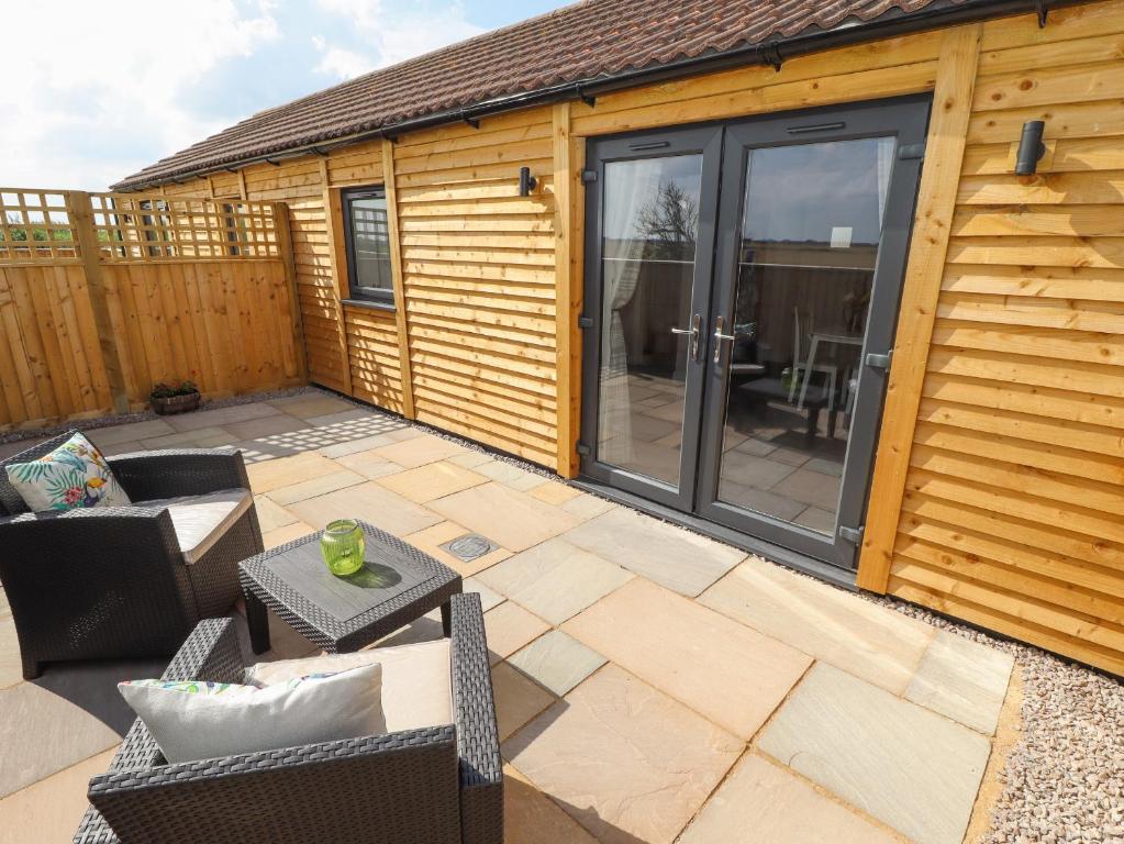a patio with a sliding glass door on a cabin at Wagtail Cottage in Mablethorpe