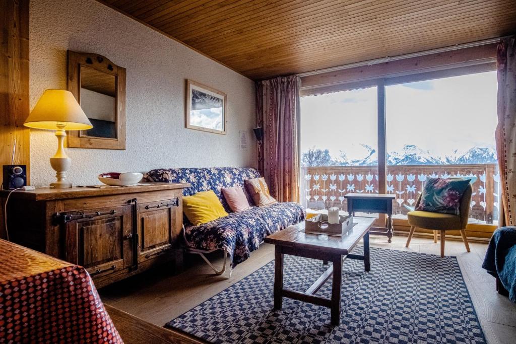 a living room with a couch and a table at Apartment with a balcony and superb view - Huez - Welkeys in LʼHuez