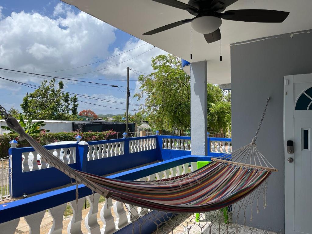 eine Hängematte, die auf einer Veranda mit einem blauen Zaun hängt in der Unterkunft 1A - Large Beach House near Crash Boat Beach in Aguadilla