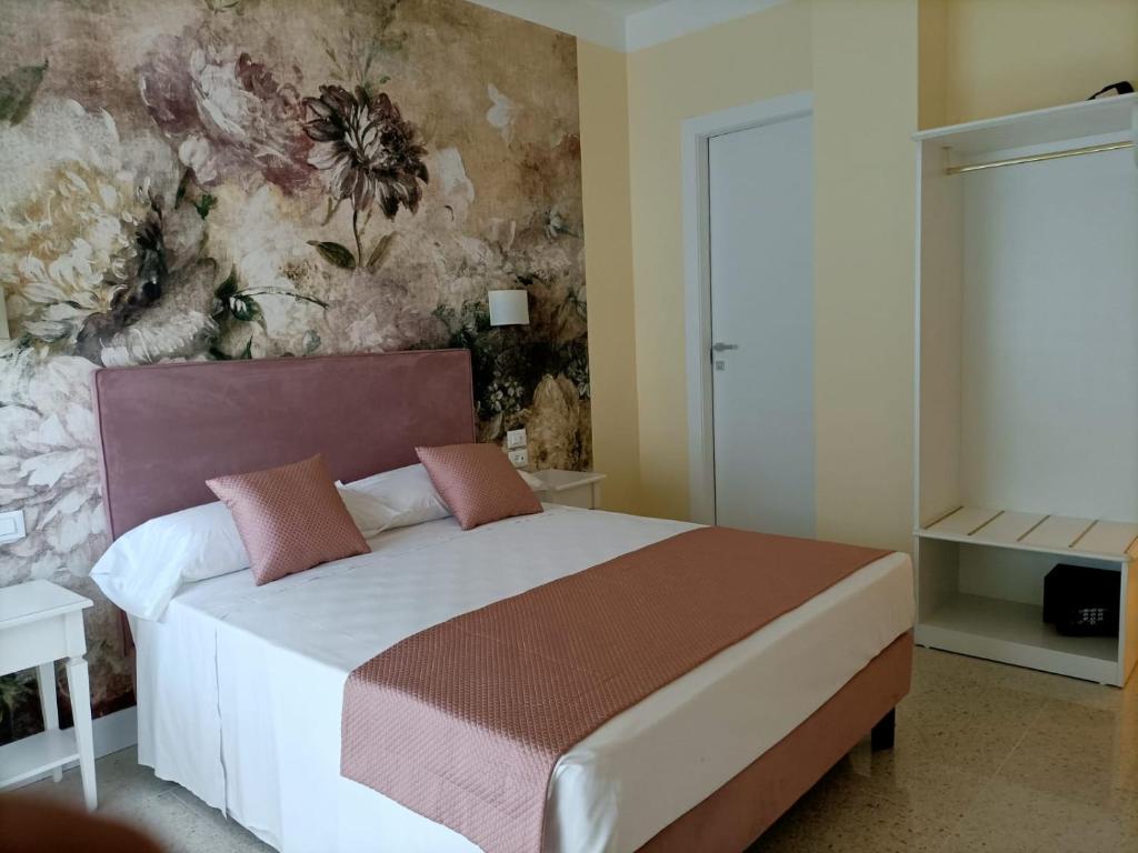 um quarto com uma cama com papel de parede florido em Atika & Atif - Guest House Train Station Venice em Mestre