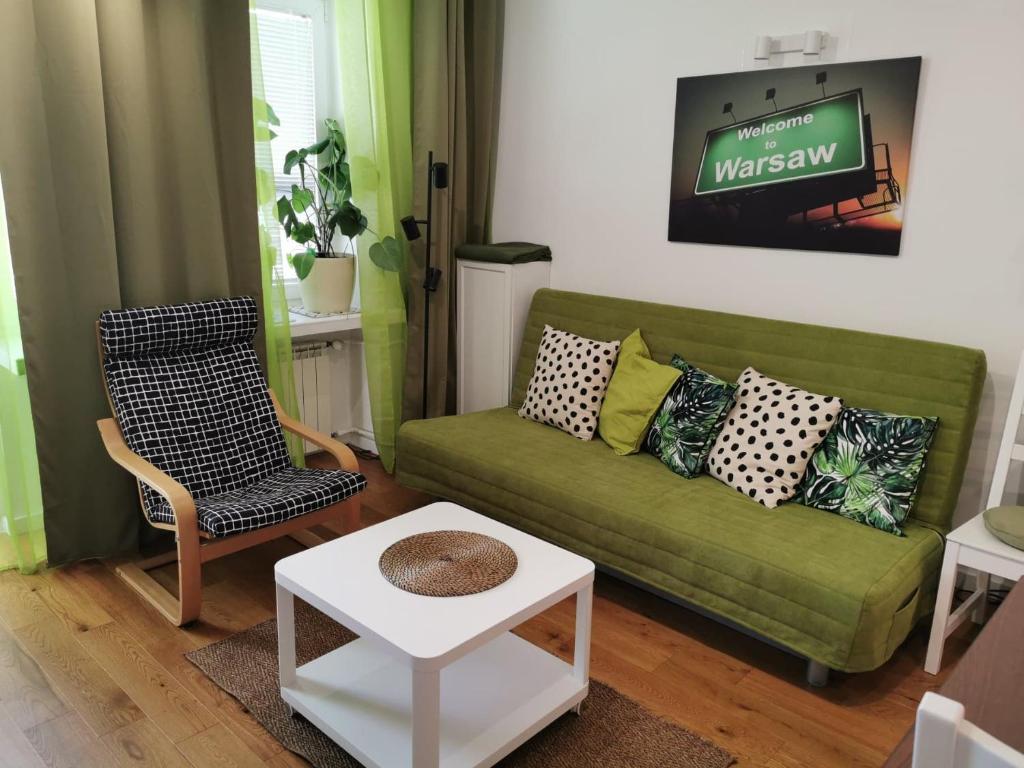 ワルシャワにあるStudio Anielewiczaのリビングルーム(緑のソファ、椅子付)