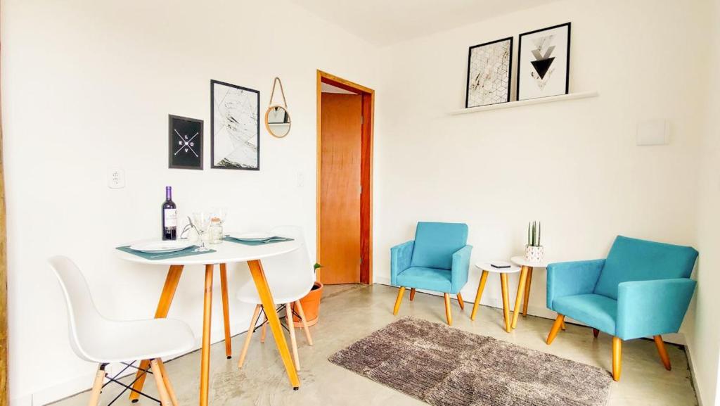 una sala da pranzo con tavolo e sedie blu di Casas no centro com o sossego da roça - Hospedado por Casa de Tijolinho a Cunha