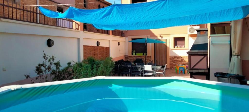 een blauw zwembad in een tuin met een patio bij Casa Rural La Pinta- SendaViva y Bardenas in Villafranca