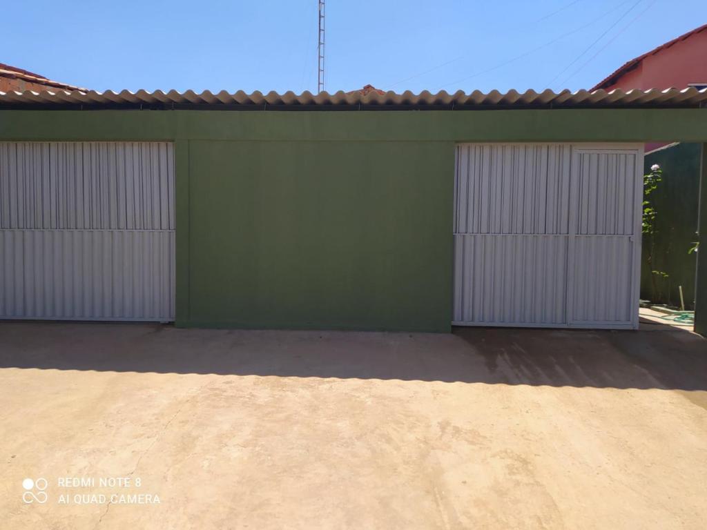 twee garagedeuren op een groen gebouw met een oprit bij Recanto da Chapada in Alto Paraíso de Goiás