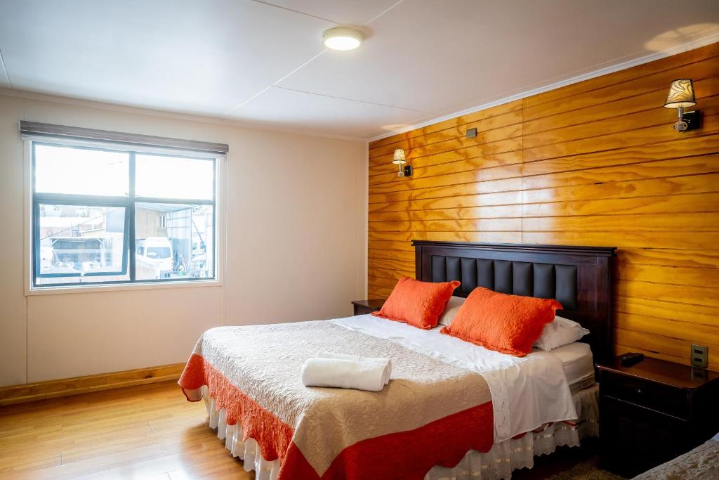 um quarto com uma cama e uma parede de madeira em Casa Lucy em Puerto Natales