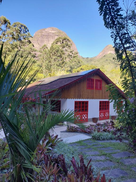 a house with a mountain in the background at Lumiar Eco Lodge - Casa Alemã in Nova Friburgo