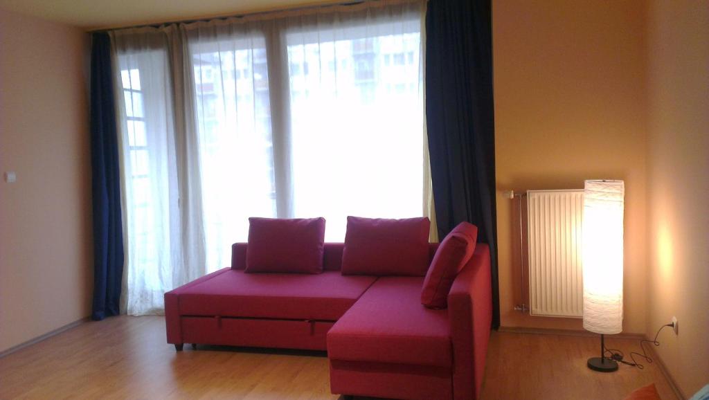 ein Wohnzimmer mit einem rosa Sofa und einem großen Fenster in der Unterkunft Apartman 4 you Wellness in Budapest