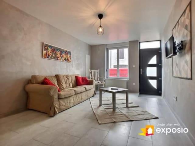 a living room with a couch and a table at Maison de ville avec petite cour in Saint-Mihiel