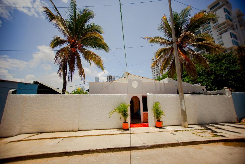 una casa blanca con palmeras delante en Casa Hotel Marbella Beach, en Cartagena de Indias