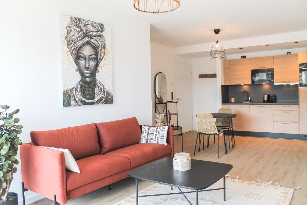 een woonkamer met een rode bank en een keuken bij African-Style Apartment in Koblenz