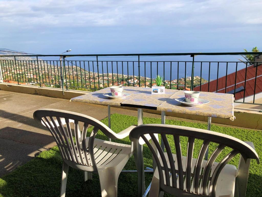 a table and chairs on a balcony with a view of the ocean at Casa AIDA SEA VIEW in Relógio do Poiso