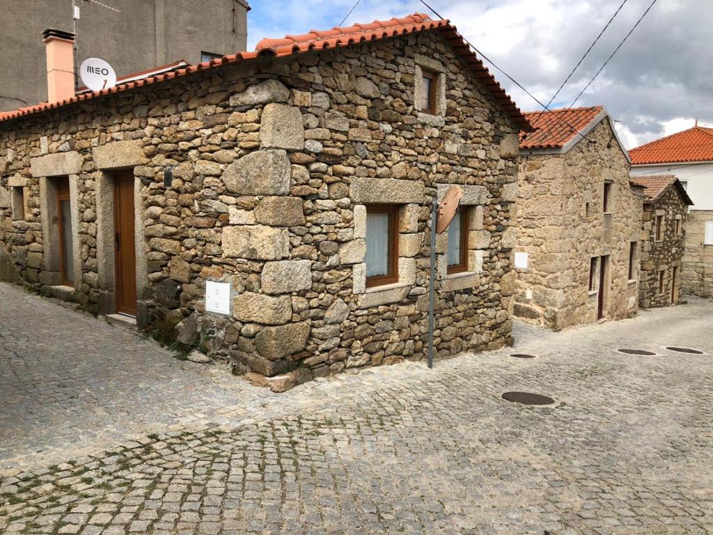 Casa de Xisto Ti Maria في Videmonte: مبنى حجري قديم على شارع مرصوف بالحصى