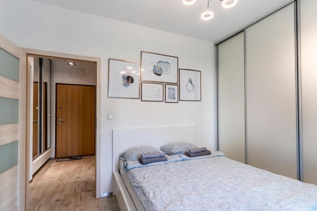 a bedroom with a bed in a white room at FIRST -- Green Żoliborz Apartment 5 in Warsaw