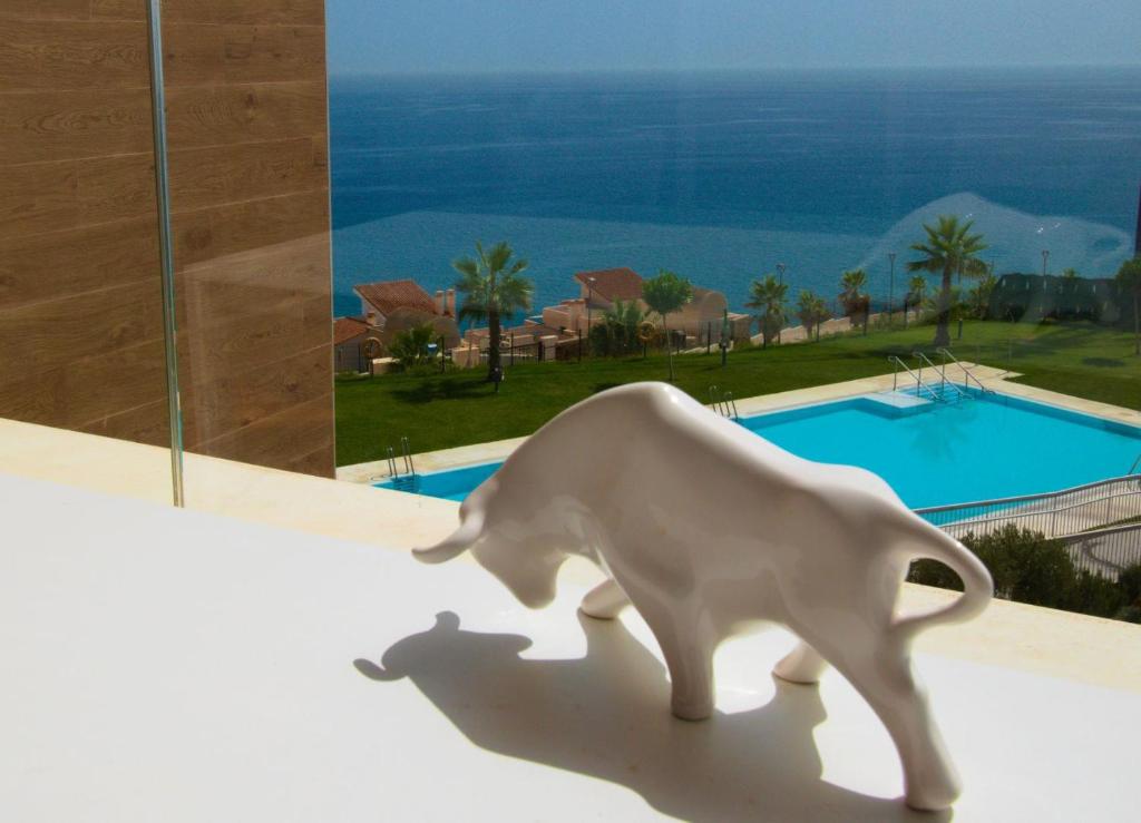 eine weiße Statue eines Stiers, der einen Schatten wirft in der Unterkunft APARTMENT BY THE SEA CALACEITE in Torrox Costa