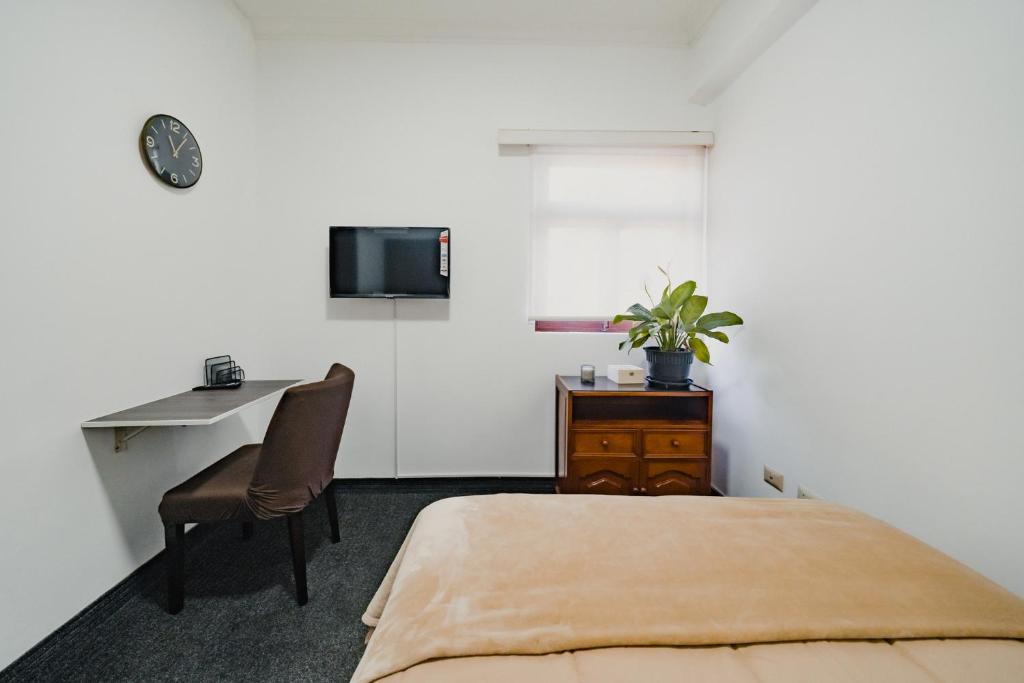 1 dormitorio con 1 cama, escritorio y TV en Miraflores Kennedy Park en Lima