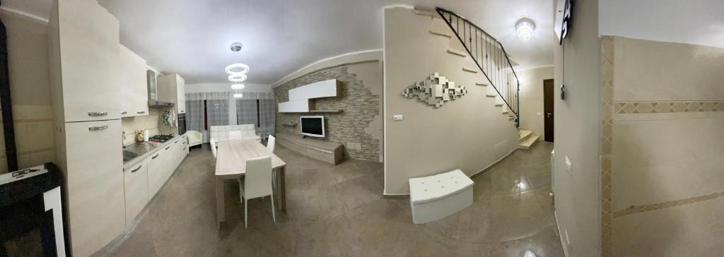eine Küche mit weißen Schränken, einem Tisch und einem Waschbecken in der Unterkunft Casa VACANZE ONELIA in Gualdo Tadino
