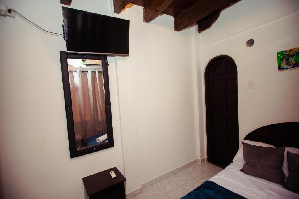 卡塔赫纳Casa Hotel Marbella Beach的卧室配有一张床,墙上配有电视