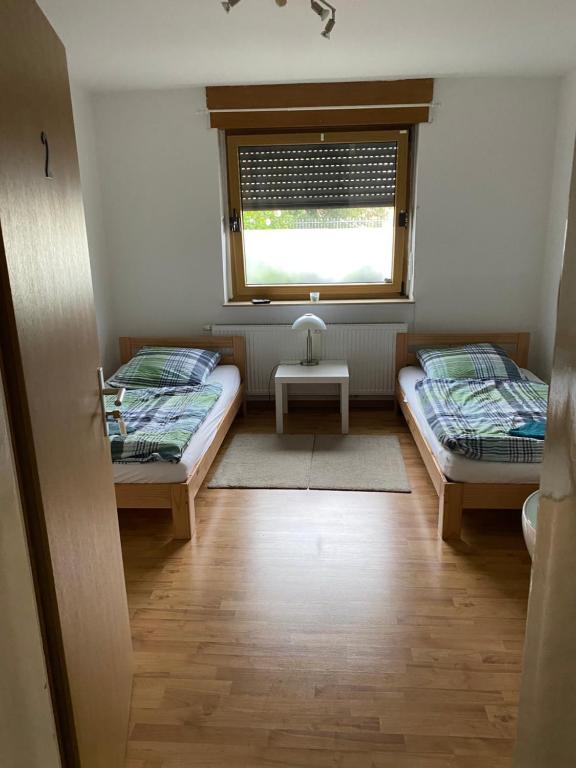 Habitación pequeña con 2 camas y ventana en Palms Zimmer en Frechen