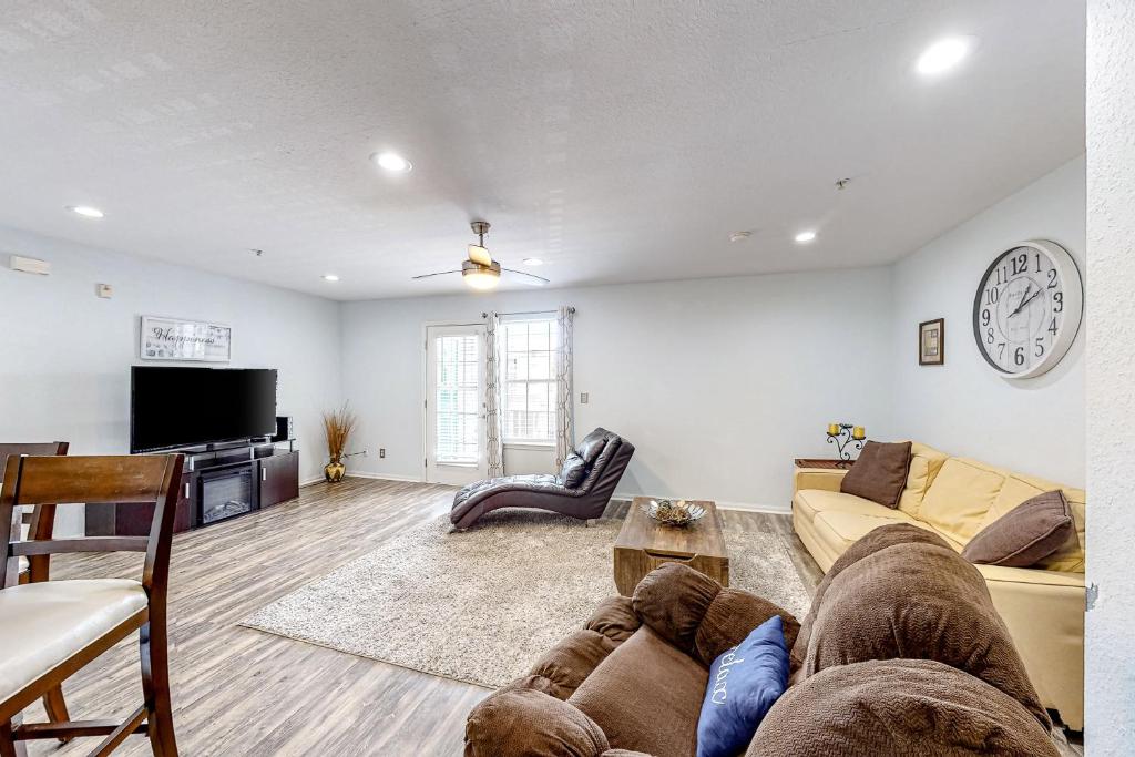 uma sala de estar com um sofá e um relógio na parede em Indian Lake 317 em Destin
