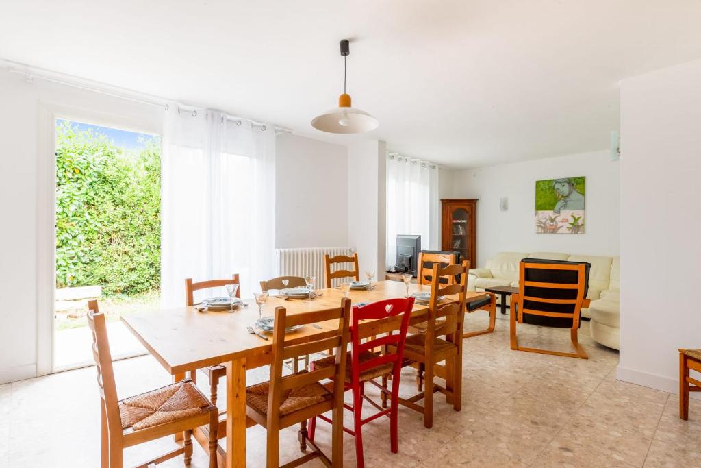 een eetkamer en een woonkamer met een tafel en stoelen bij Nice house with a yard - La Rochelle - Welkeys in Puilboreau