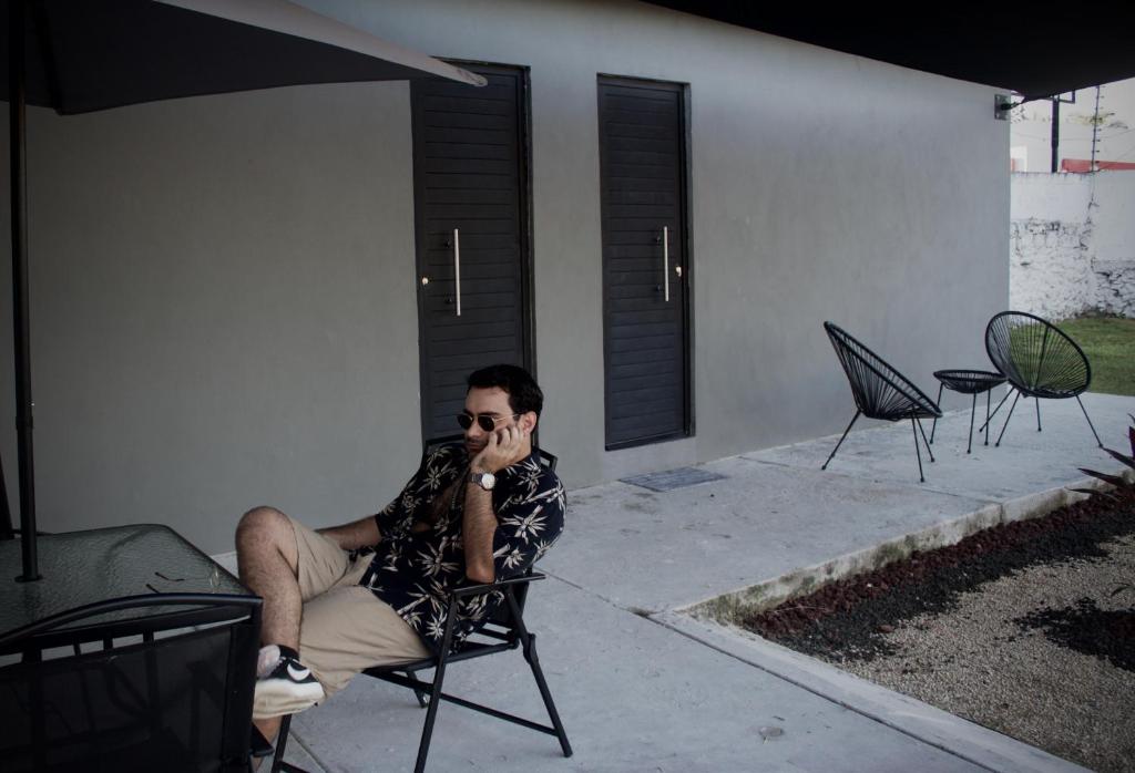 un homme assis dans une chaise et parlant sur un téléphone portable dans l'établissement Türk, à Chetumal
