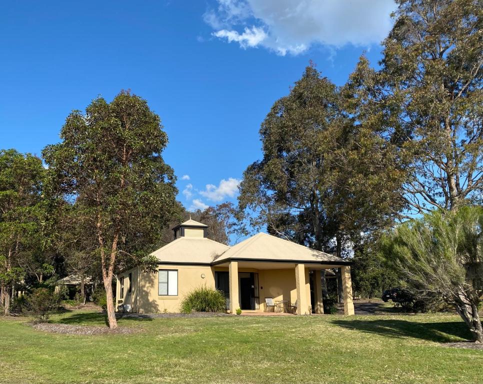 a house with trees in front of it at Beautiful Villa in the heart of the Hunter Valley in Pokolbin