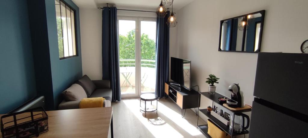 sala de estar con sofá y TV en Indy Appart - T2 moderne, calme, propre, parking, balcon vue, en Saint-Priest