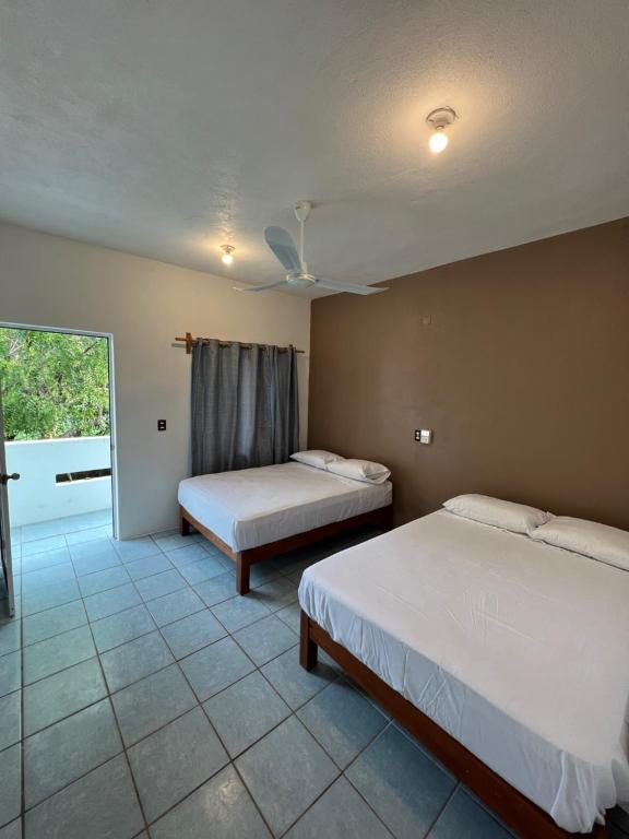 - une chambre avec 2 lits et une fenêtre avec vue dans l'établissement Single Fin Suites & Rooms La punta zicatela, à Brisas de Zicatela