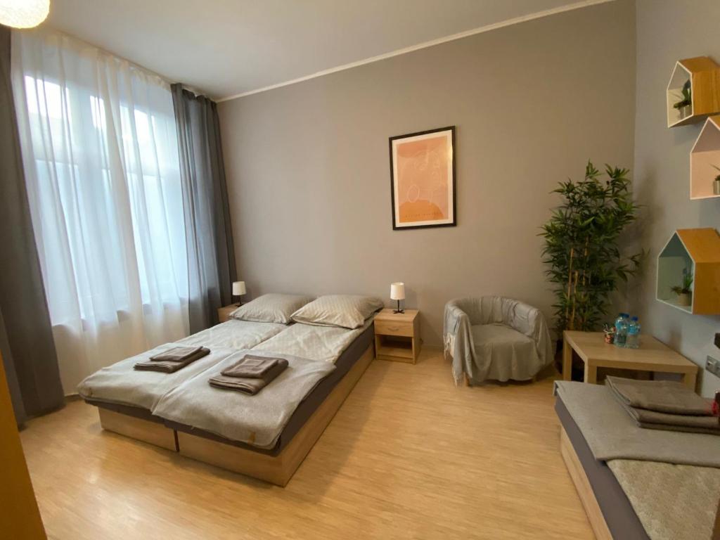 a bedroom with a large bed and a chair at Hostel Rynek22 in Gliwice