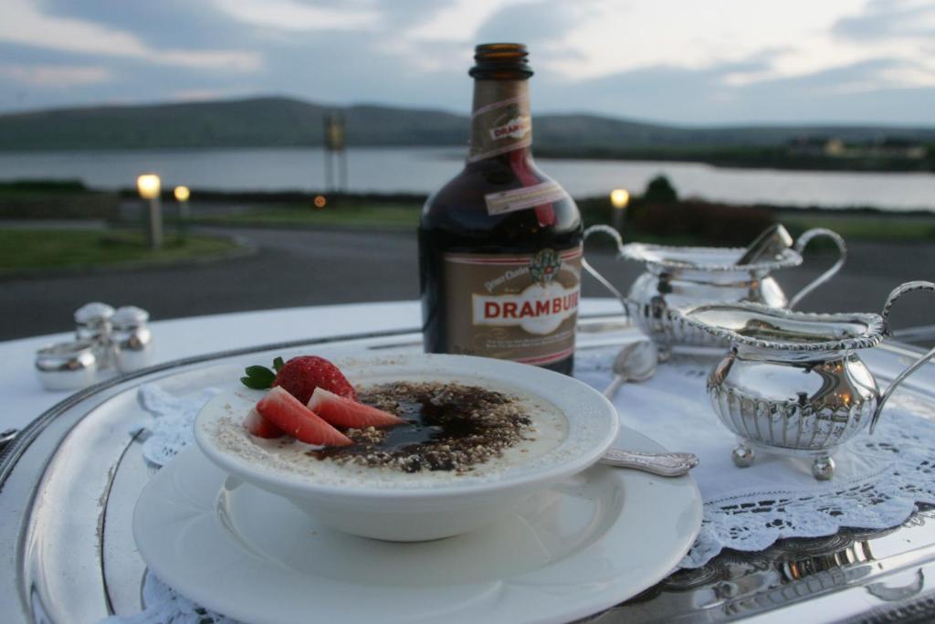 una ciotola di cibo su un tavolo con una bottiglia di vino di Heatons Guesthouse a Dingle
