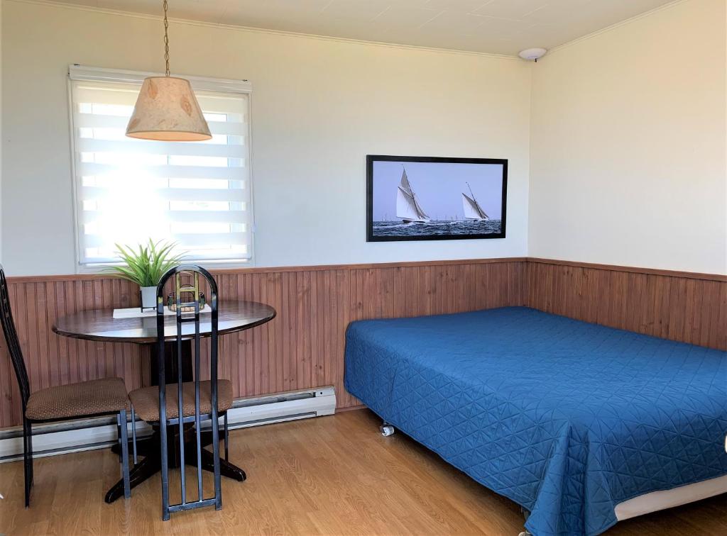 Una cama o camas en una habitación de Complexe Cap-Chat