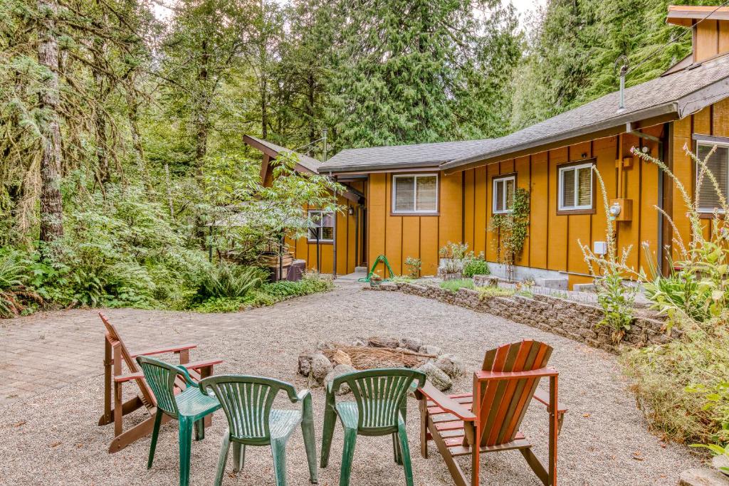 um grupo de cadeiras e uma fogueira em frente a uma casa em Creekside Cabin em Rhododendron