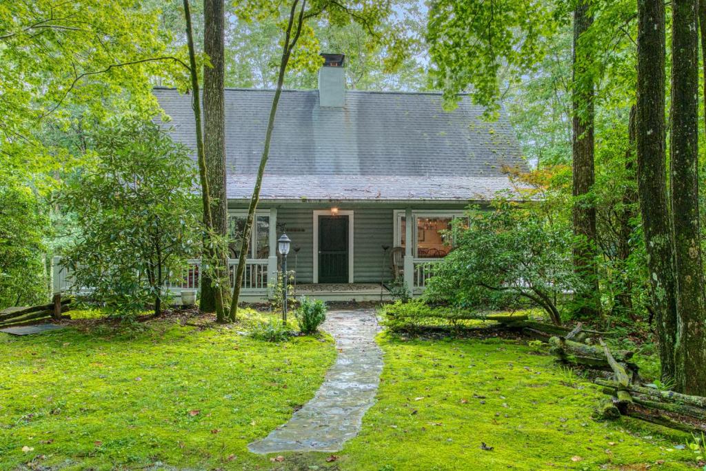 a house in the woods with a pathway in front of it at Laurel Cabin in Cashiers