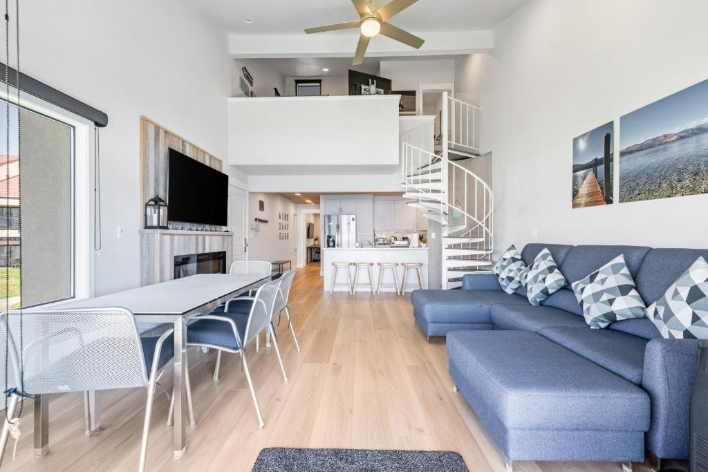 a living room with a blue couch and a table and chairs at Lake Chelan Shores - Beachfront Sunsets #6-5 in Chelan