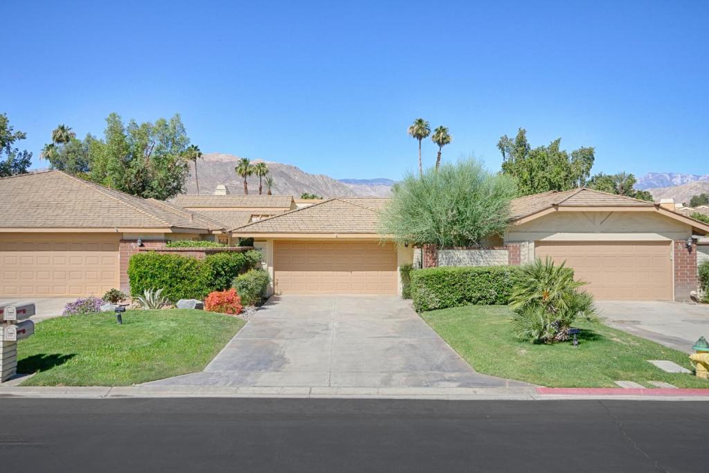 a house with a driveway in a residential neighborhood at Sunshine On My Shoulders Permit# STR2022-0160 in Palm Desert