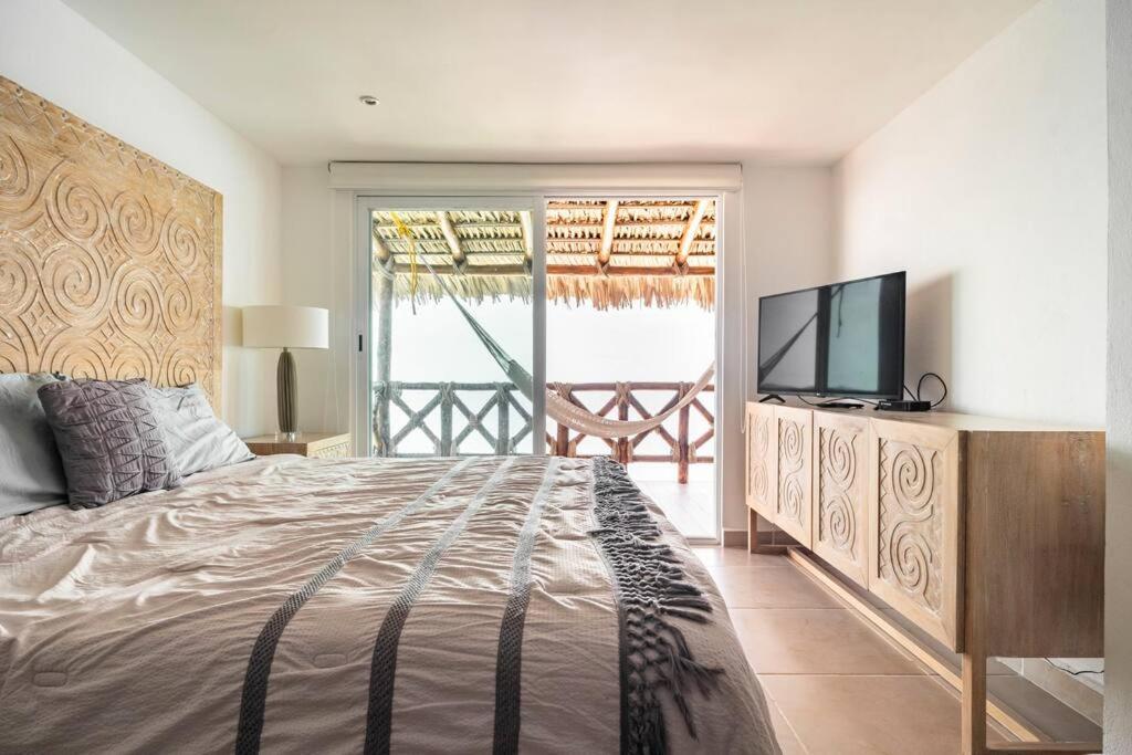 een slaapkamer met een groot bed en een televisie bij Bello Departamento Veleros frente al mar in Acapulco