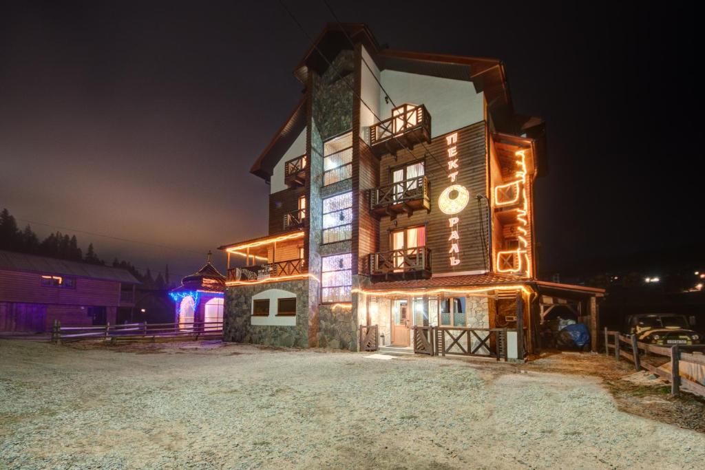 un bâtiment avec des lumières allumées la nuit dans l'établissement Pektoral, à Bukovel
