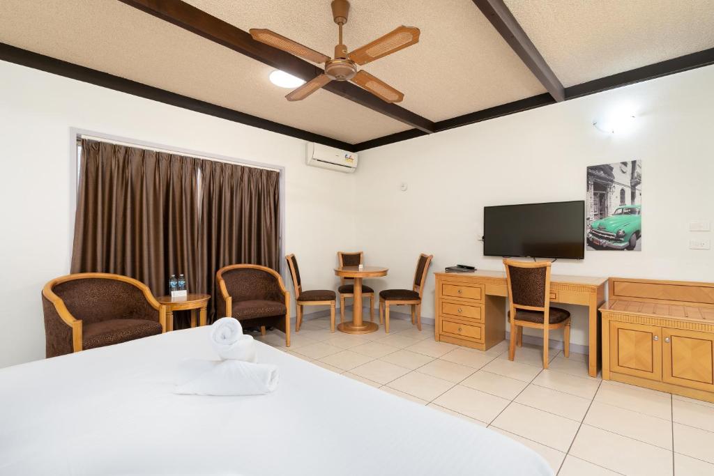 a hotel room with a bed and a desk and a tv at Apollo Motel Biloela in Biloela