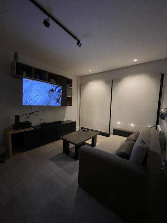 sala de estar con sofá y Tv LED en Departamento Moderno - Equipado y Con Cochera Privada en Mar del Plata